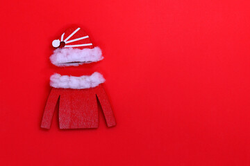 Wooden hat and jacket of Santa Claus on a red background, a place to copy the text