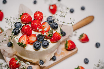 Beautiful strawberry cake decorated with blueberries on a white background
