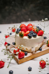 Beautiful strawberry cake decorated with blueberries on a white background