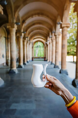 Mug for drinking hot mineral therapeutic water on the background of a gallery with columns. A...