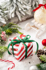 Christmas striped gift box with green ribbon bow, winter decorations