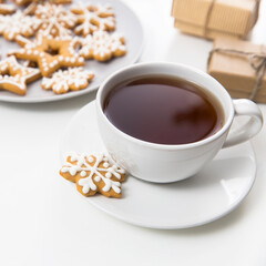 Cup of coffee with gingerbread christmas cookies in the form of stars on a white table. Copy space