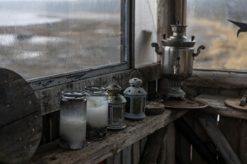 Kola Peninsula, Russia. Tersky coast of the White sea. Complex Tony Tetrina. The reconstructed village of Pomors. Lamps, lanterns, candles, samovar stand on the bath's windowsill. It's raining outside