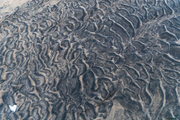 Black sand with traces of waves on the White Sea