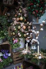 Fototapeta na wymiar LONDON, UK - DECEMBER, 01 2019: Flower shop on the eve of Christmas. Sale of Christmas wreaths, white cotton, blue violets, glass decorations for the Christmas tree.