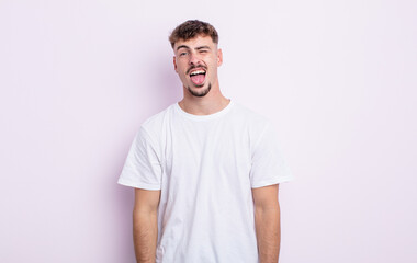young handsome man with cheerful, carefree, rebellious attitude, joking and sticking tongue out,...