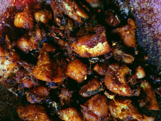 Fried chicken pieces in a bowl with oil indian style, added chilli powder