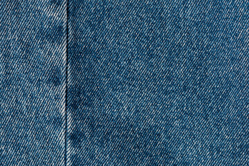 blue denim texture with side seam. thread stitches on the background of denim textiles. a place to copy. Abstract background and texture for design.