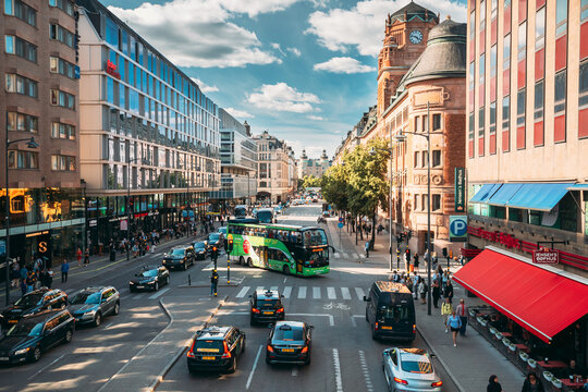Stockholm, Sweden. Red Hop On Hop Off Touristic Bus For Sightseeing Riding Down The Vasagatan Street. City Tour Bus.