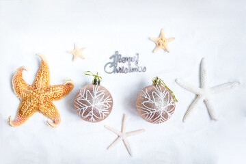 Christmas sand beach background, Christmas-tree decoration ball with starfish at ocean beach, Xmas and New Year holiday vacation celebrating in tropical zone concept.