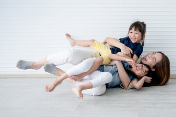 Fototapeta na wymiar Asian family, mother and two daughters, ages 3 and 6, are plying happily and having fun, with white background, to relationship family and mental health children concept.