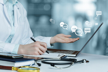 Doctor is in correspondence with patients on a laptop in the hospital.