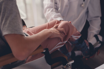 Young man with disability receive checking the protective equipment for leg and foot injuries by a kind doctor, Activity of people with disabilities in hospital or quarantine, Healthcare concept.