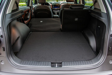 Huge, clean and empty car trunk in interior of compact suv. Rear view of a SUV car with open trunk - obrazy, fototapety, plakaty