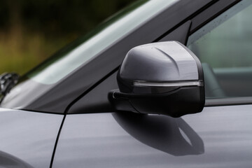 Close up front view of car side mirror. Front rear view mirror on the car window. Car exterior details.