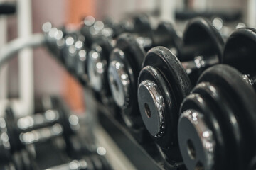 Obraz na płótnie Canvas A rack with dumbbells in the gym or fitness club. Doing sports and fitness. Bodybuilding.