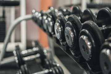 A rack with dumbbells in the gym or fitness club. Doing sports and fitness. Bodybuilding.