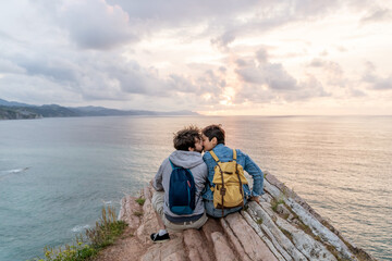 Horizontal view of young couple in love sightseeing in Zumaia cliffs. Horizontal panoramic view of young couple traveling in vasque country. People and travel destination in Spain