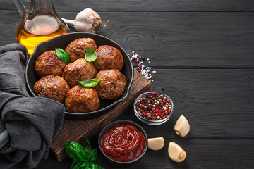 Fried meatballs with sauce and spices in a frying pan.