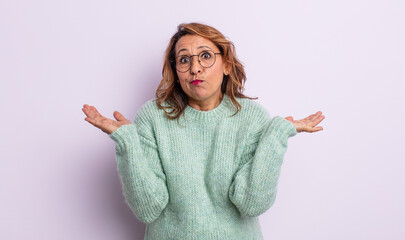 middle age woman feeling puzzled and confused, doubting, weighting or choosing different options...