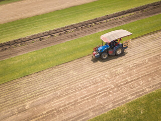 Aerial Drone Photo of Farmer Harvesting lawn rolls.