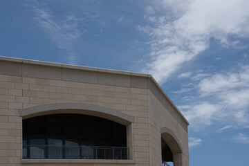 Roof corner of an octagon-shaped building ander blue summer sky with some clouds