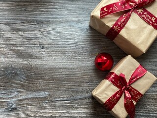 Fototapeta premium Christmas background with Christmas gifts and a Christmas tree toy. Gift boxes tied with a bow. For the background