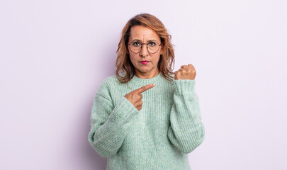 middle age woman looking impatient and angry, pointing at watch, asking for punctuality, wants to...