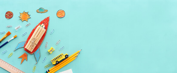 Fototapeta premium education. Back to school concept. rocket cut from paper and painted over blue wooden background. top view, flat lay