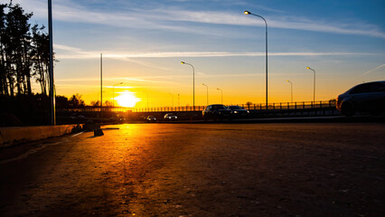  the evening sun on the blue sky is the road at sunset.Cars are going into the sunset.Stripes from planes