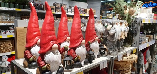 Figurines of gnomes in red caps in the store. New year toys. New Year's decorations.