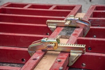 Clamps connect the red shuttering boards