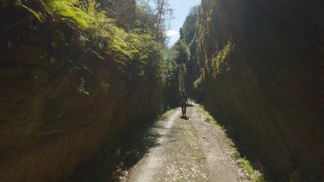 Escursionista cammina su un sentiero stretto
