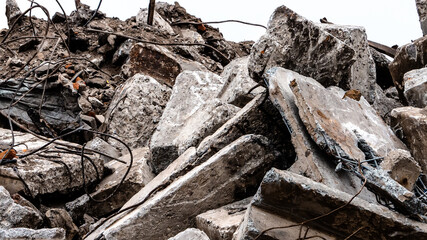 Remains of the demolished building close-up. Concrete debris and bent reinforcing bars