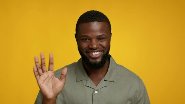 Hi. Portrait Of Positive Cheerful Black Guy Waving Hand At Camera