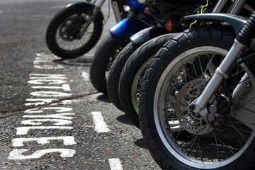 Front wheels of motorcycles parked in a bay