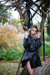 European white young woman with blonde hair with trees behind in park