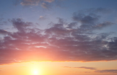 Fototapeta premium Dawn sky in the form of dramatic clouds over the bright sun.