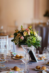 Wedding celebration venue table set up with colourful flowers and glassware