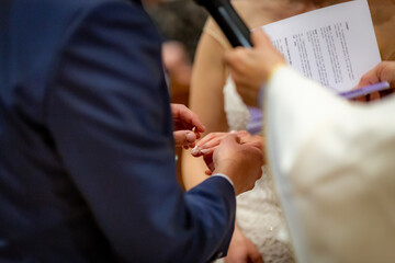 Obraz na płótnie Canvas Special moment of groom put golden ring on brides finger in wedding ceremony
