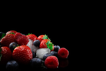 natural eco-friendly natural fresh raspberries, strawberries and blueberries with ice on a black background isolate