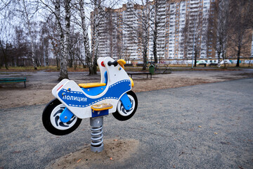 Swing in the form of a police motorcycle on a playground in Russia. The inscription on the motorcycle in Russian - Police
