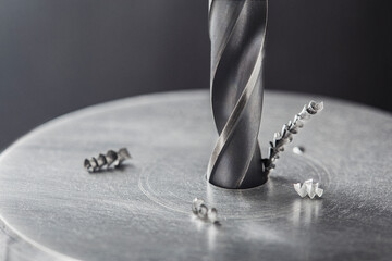 metal drill bit make holes in steel billet on industrial drilling machine. Metal work industry....