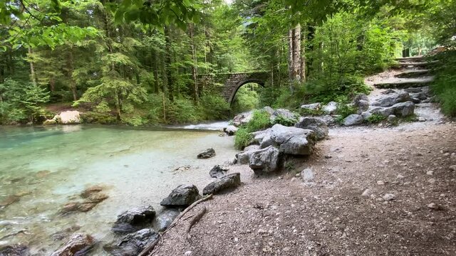 Kamnik, Slovenia - 29 July, 2021: River Bistrica in Slovenia, bridge and a cyclist driving over the bridge