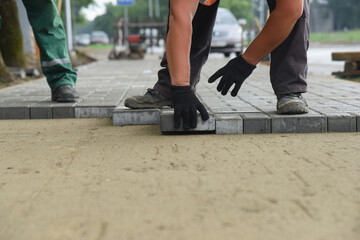 A bricklayer lays paving slabs, repairs and replaces the road surface.