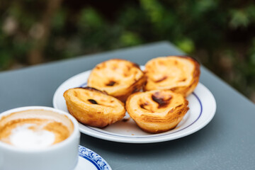 Egg custard tarts called Pasteis de Nata with two coffees 