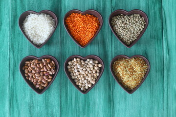 Different type of raw dry legumes composition. White Rice, lentils, red lentils, chickpeas and kidney beans. Mix organic legume concept. With Heart shape bowl. 