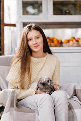 teen girl playing with pet rabbit on the farm