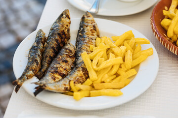 Grilled sardines with french fries served for lunch