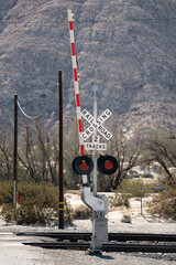 A Railroad crossing barracade in the desert.